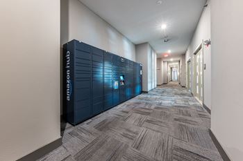 a long hallway with blue lockers in the middle of it at The Monroe Apartments, Austin, 78741